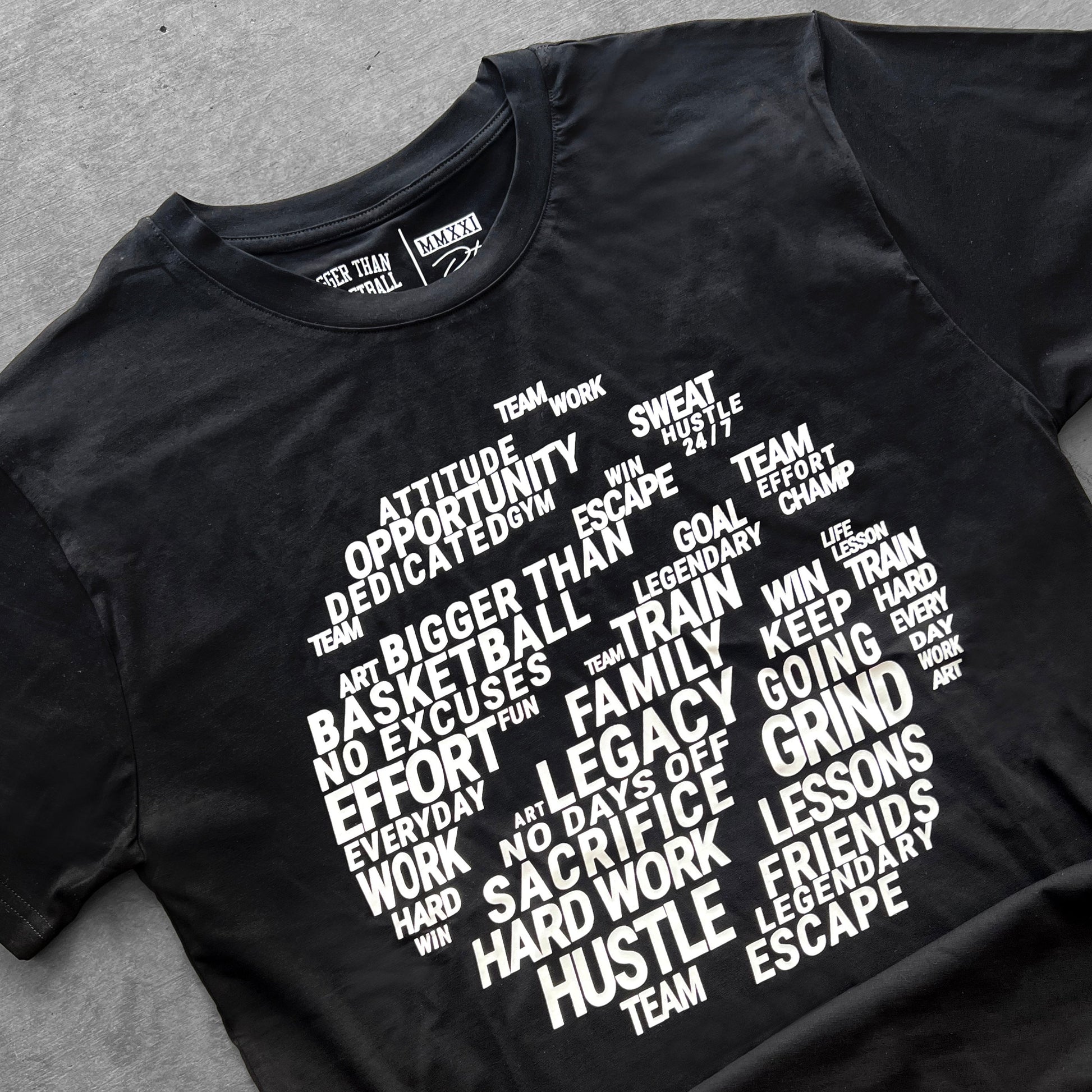 Black t-shirt with white motivational text design on a gray surface