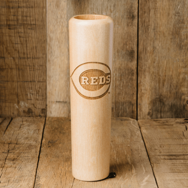 Wooden baseball bat with 'REDS' engraving on a wooden background