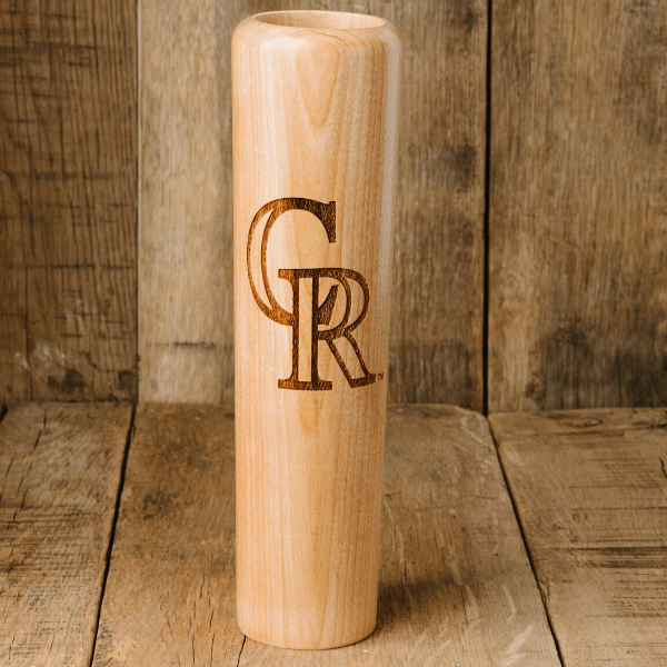 Wooden vase with engraved initials 'GR' on a wooden background