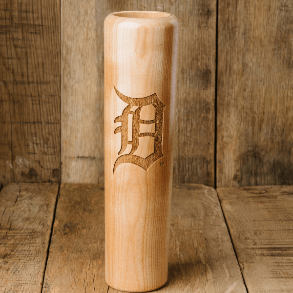 Wooden baseball bat with a laser-cut logo on a wooden background
