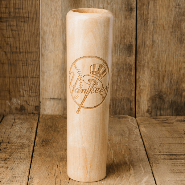 Wooden baseball bat with 'Yankees' engraving on a wooden background