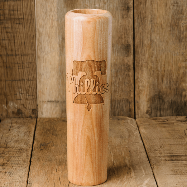 Wooden baseball bat with 'Phillies' engraving on a wooden background