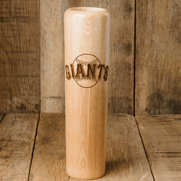 Wooden baseball bat with 'GIANTS' engraving on a wooden background