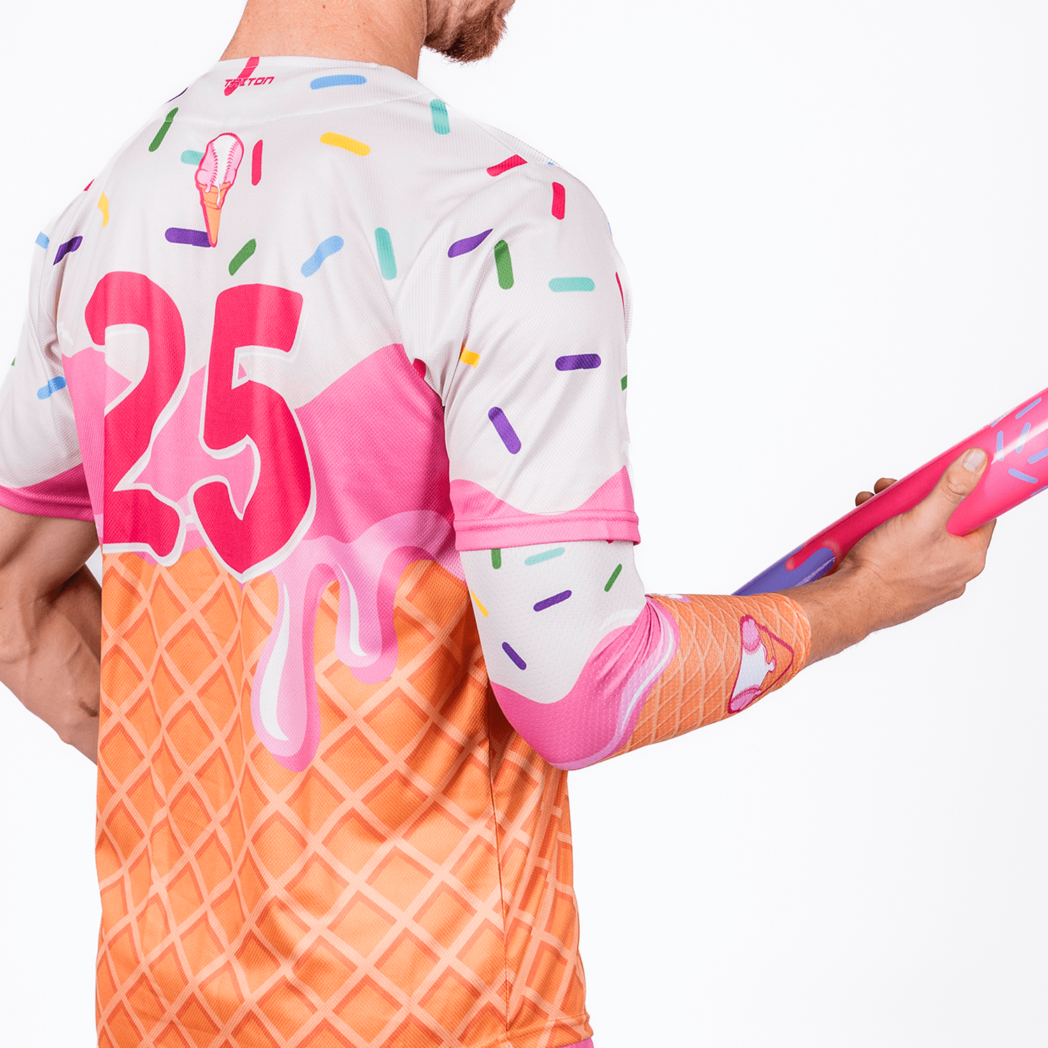 Collection of Person wearing a colorful ice cream-themed shirt with the number 25, holding a pink object. in a gallery layout