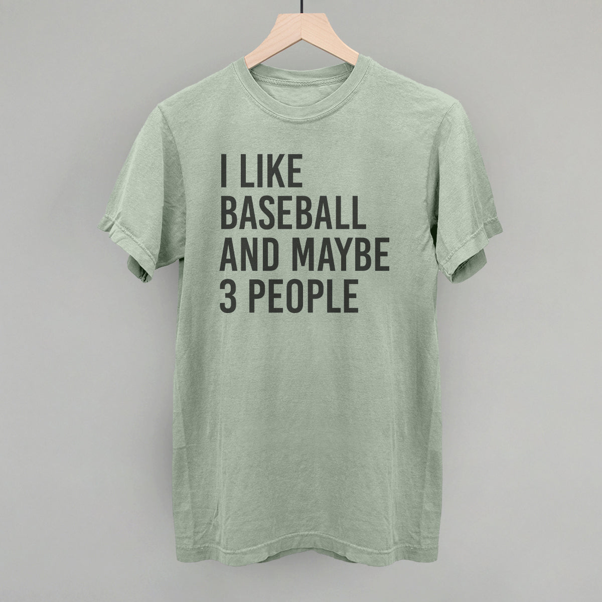 Green t-shirt with text 'I like baseball and maybe 3 people' on a gray background