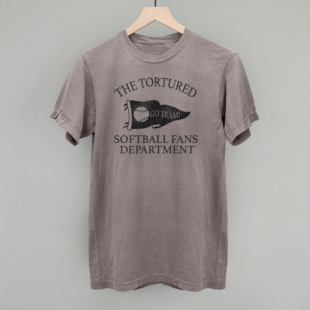 Collection of Gray t-shirt with 'The Tortured Softball Fans Department' text and graphic on a hanger against a gray background in a gallery layout