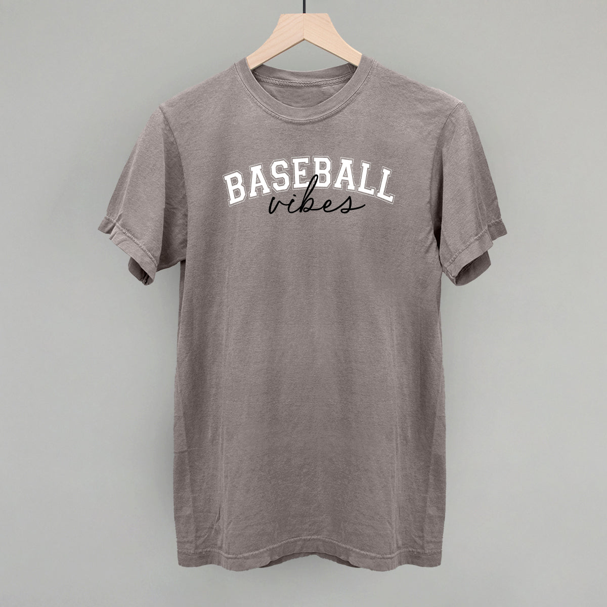 Gray t-shirt with 'Baseball vibes' text on a hanger against a gray background