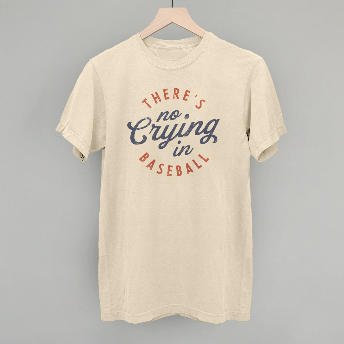 Beige t-shirt with 'There's no crying in baseball' text on a gray background
