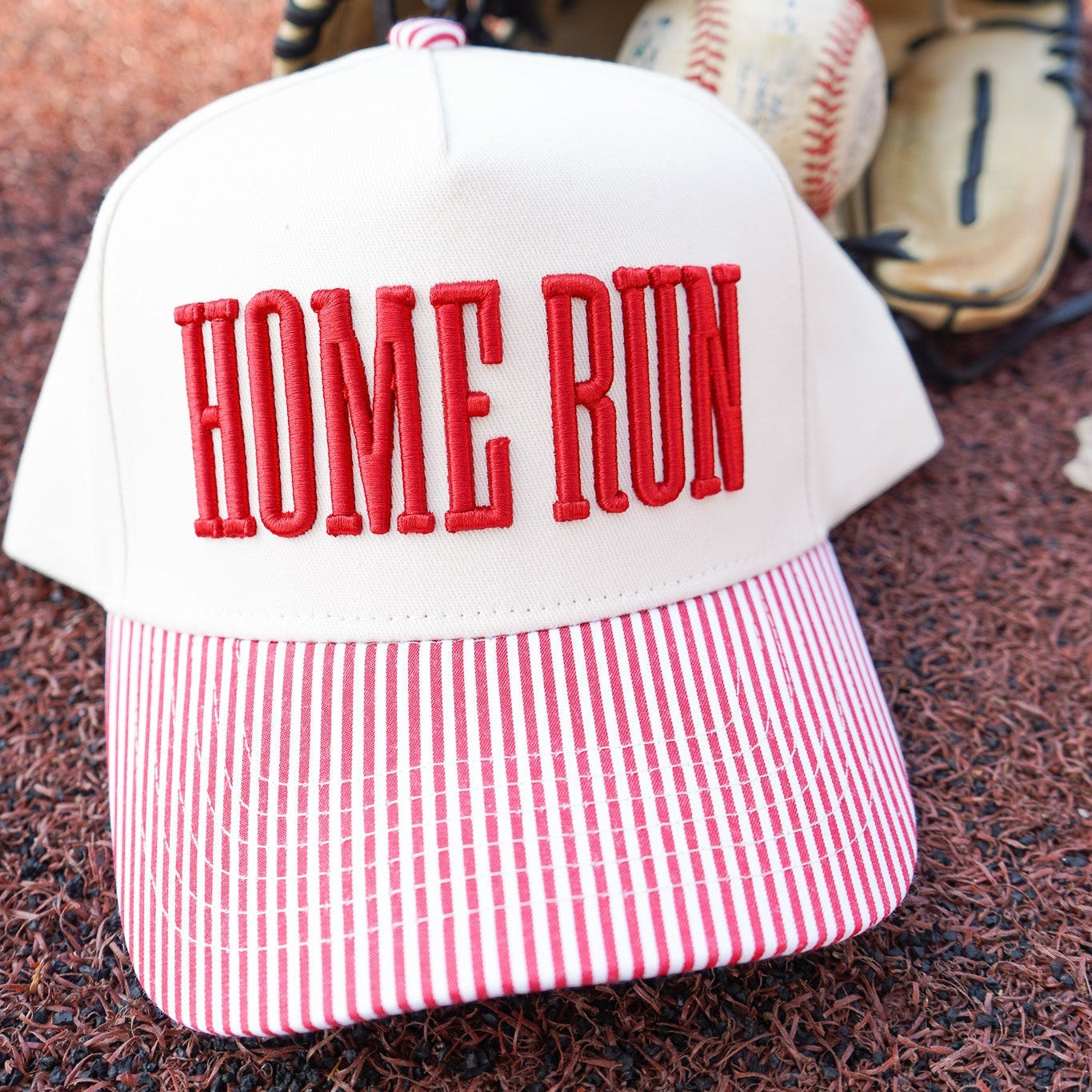 Collection of Baseball cap with 'HOME RUN' text on a baseball field, next to a baseball and glove. in a gallery layout