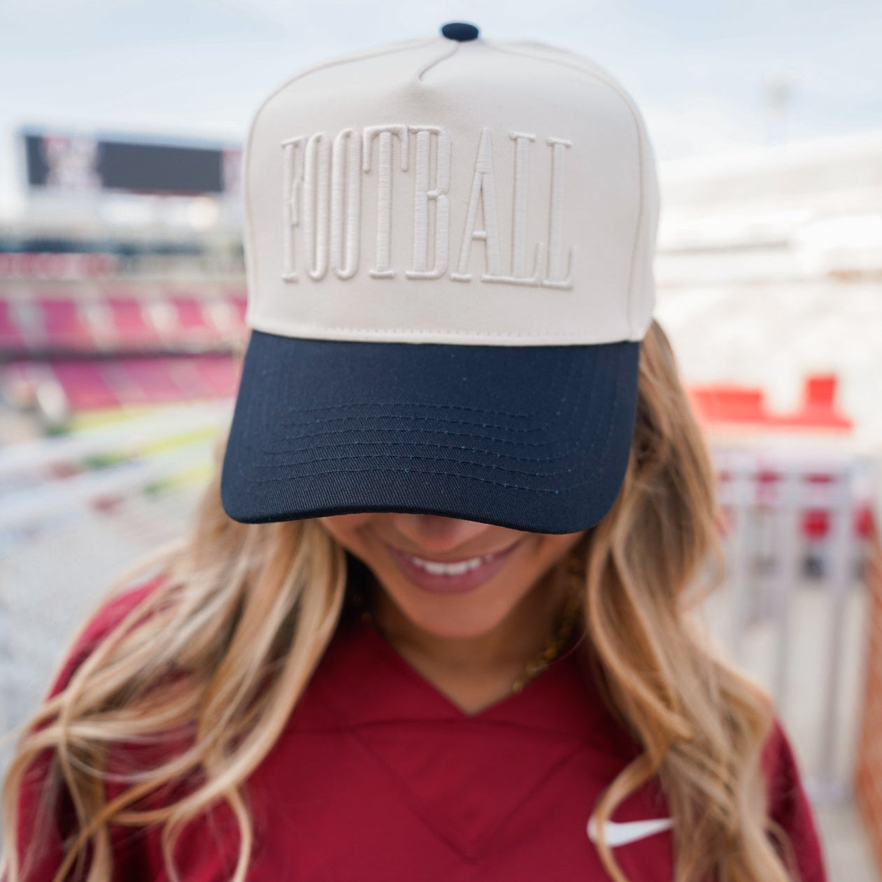 Collection of Person wearing a cap with 'FOOTBALL' and a red 'ARKANSAS' shirt in an outdoor setting. in a gallery layout