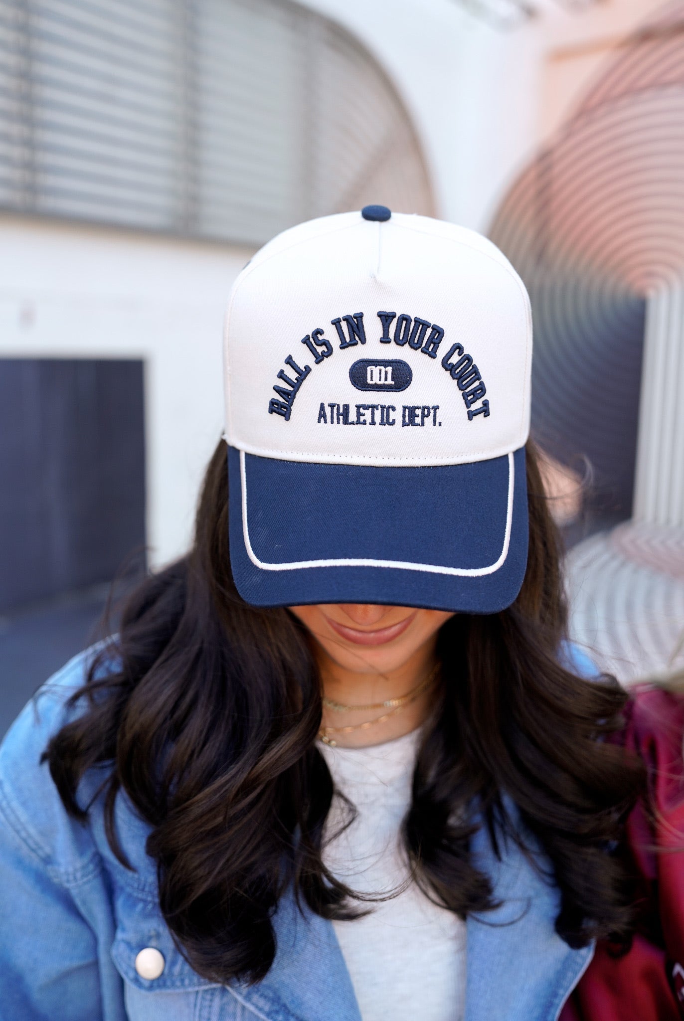 Person wearing a white and blue cap with text, blurred background