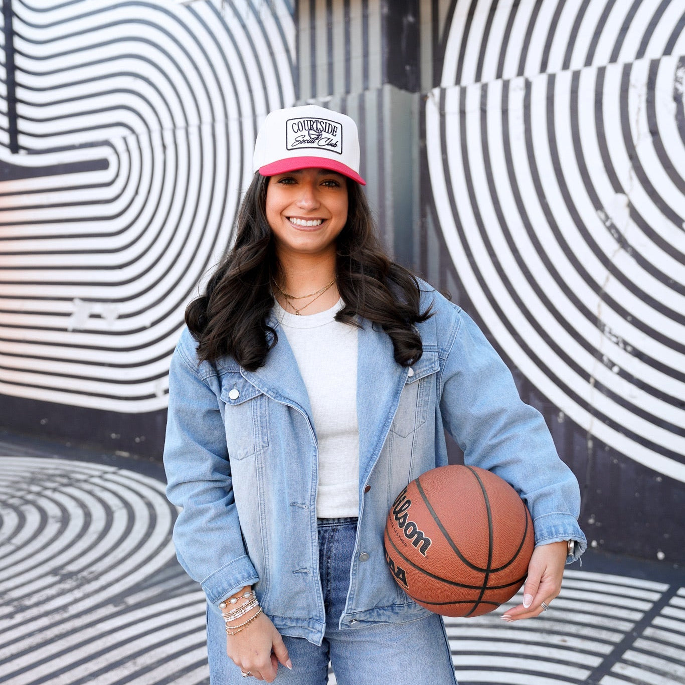 Collection of Person holding a basketball in front of a mural with concentric circles in a gallery layout