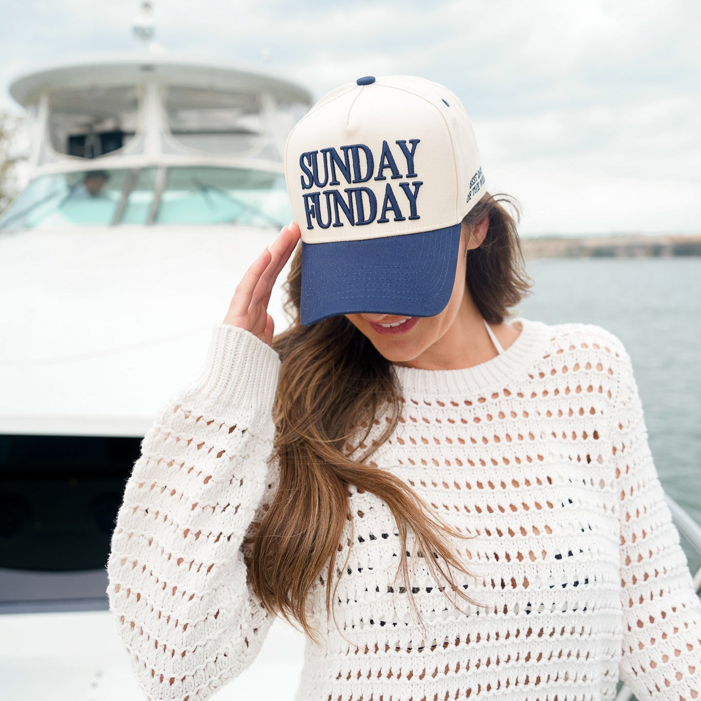 Woman wearing a 'Sunday Funday' cap on a boat