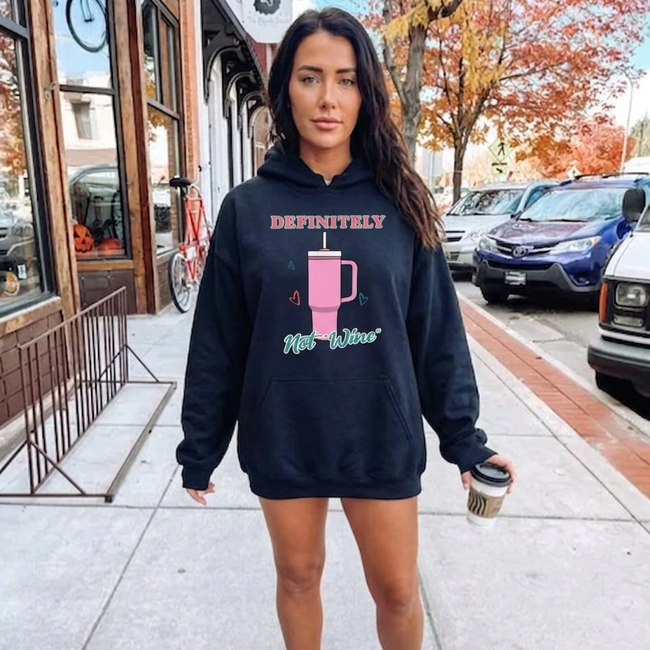 Collection of Woman wearing a black hoodie with text and graphics, standing on a sidewalk. in a gallery layout