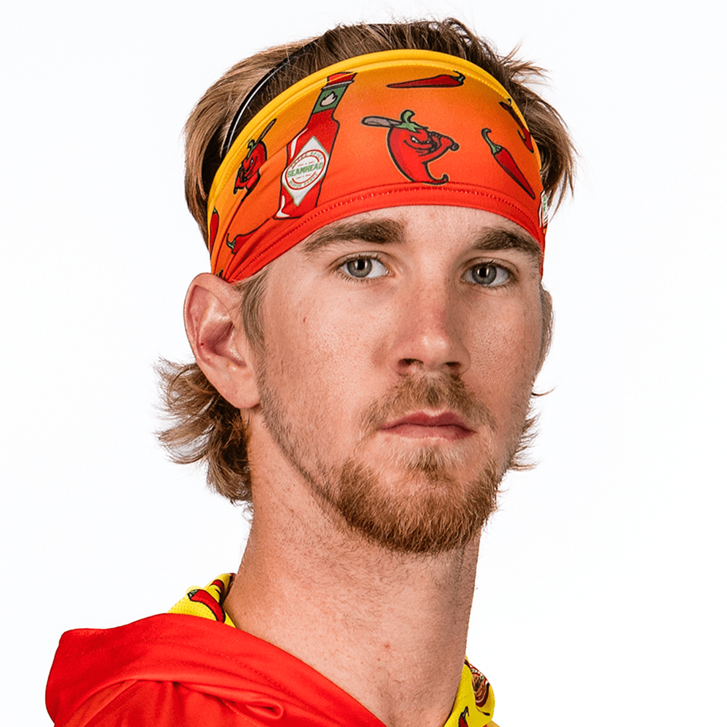 Man wearing a colorful headband with chili pepper design on a white background