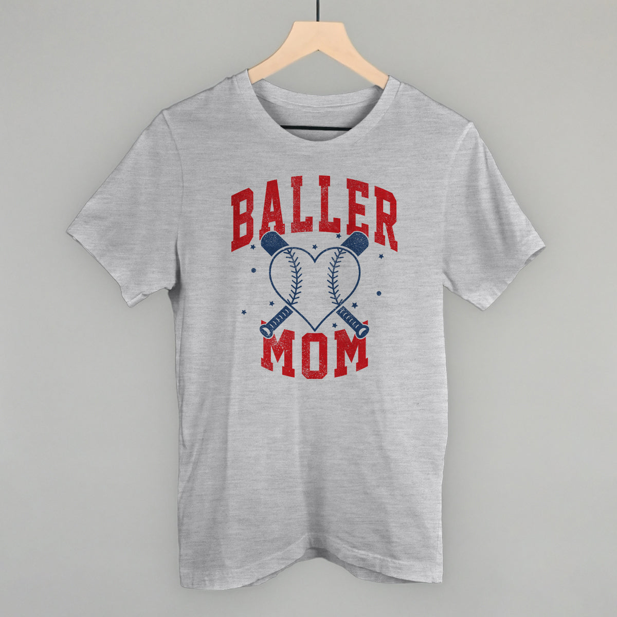 Collection of Gray t-shirt with 'Baller Mom' text and graphic on a hanger against a gray background in a gallery layout