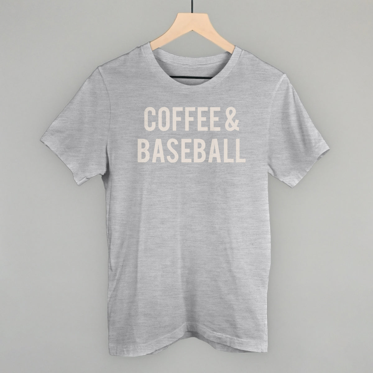 Gray comfort colors t-shirt with 'COFFEE & BASEBALL' text on a hanger against a gray background