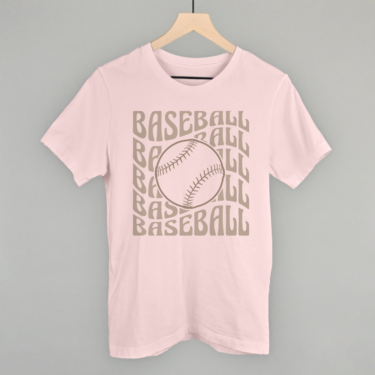 Pink t-shirt with 'BASEBALL' text and baseball graphic on a hanger against a gray background