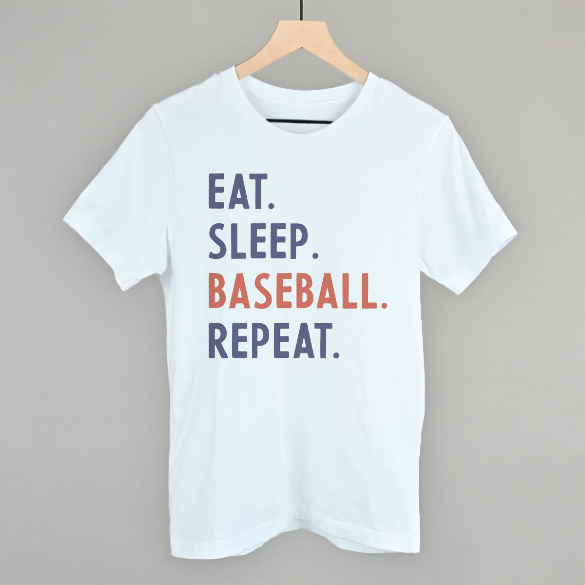 White t-shirt with 'EAT. SLEEP. BASEBALL. REPEAT.' text on a gray background