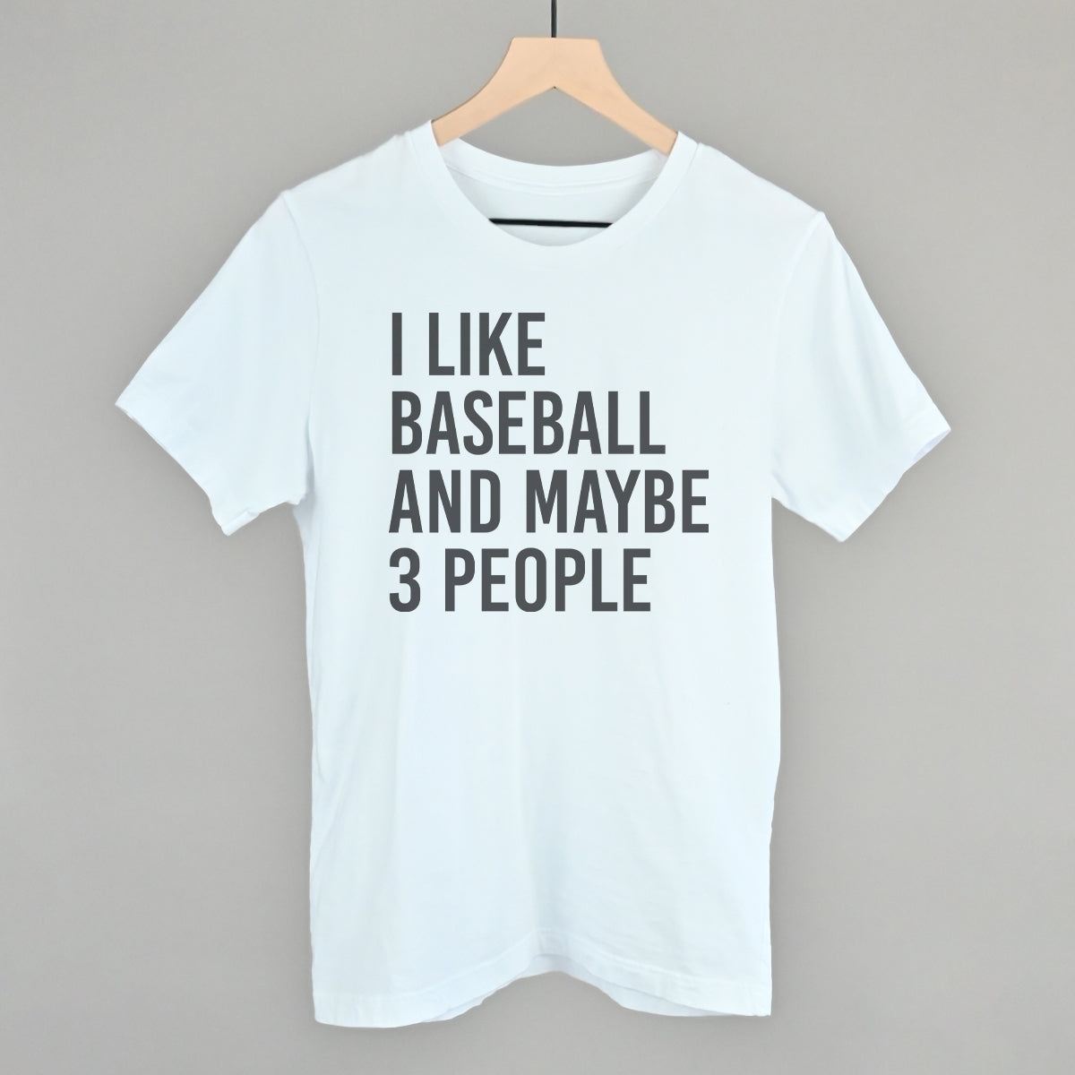 Collection of White t-shirt with 'I LIKE BASEBALL AND MAYBE 3 PEOPLE' text on a hanger against a gray background in a gallery layout