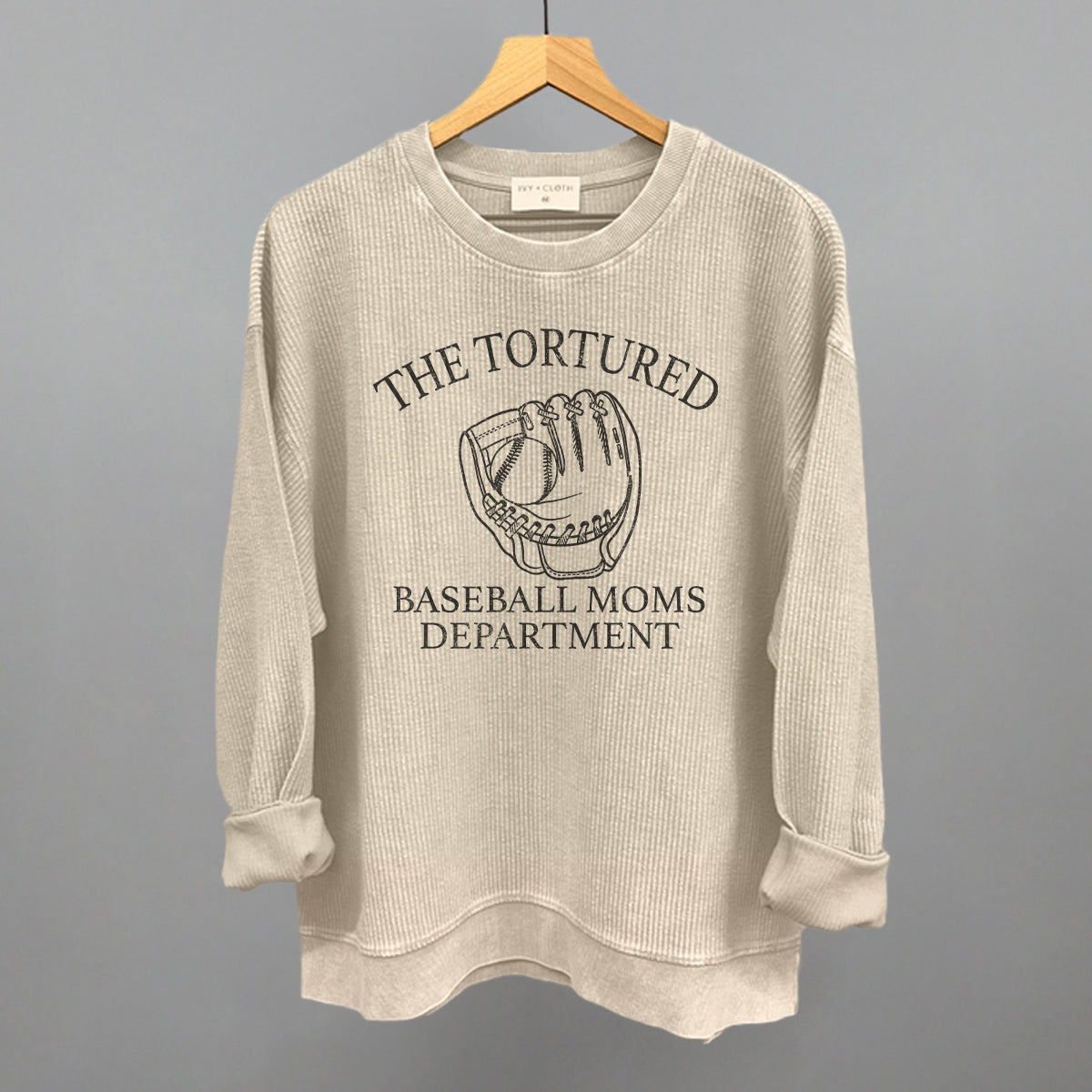 Collection of Beige sweatshirt with graphic and text on a hanger against a gray background in a gallery layout