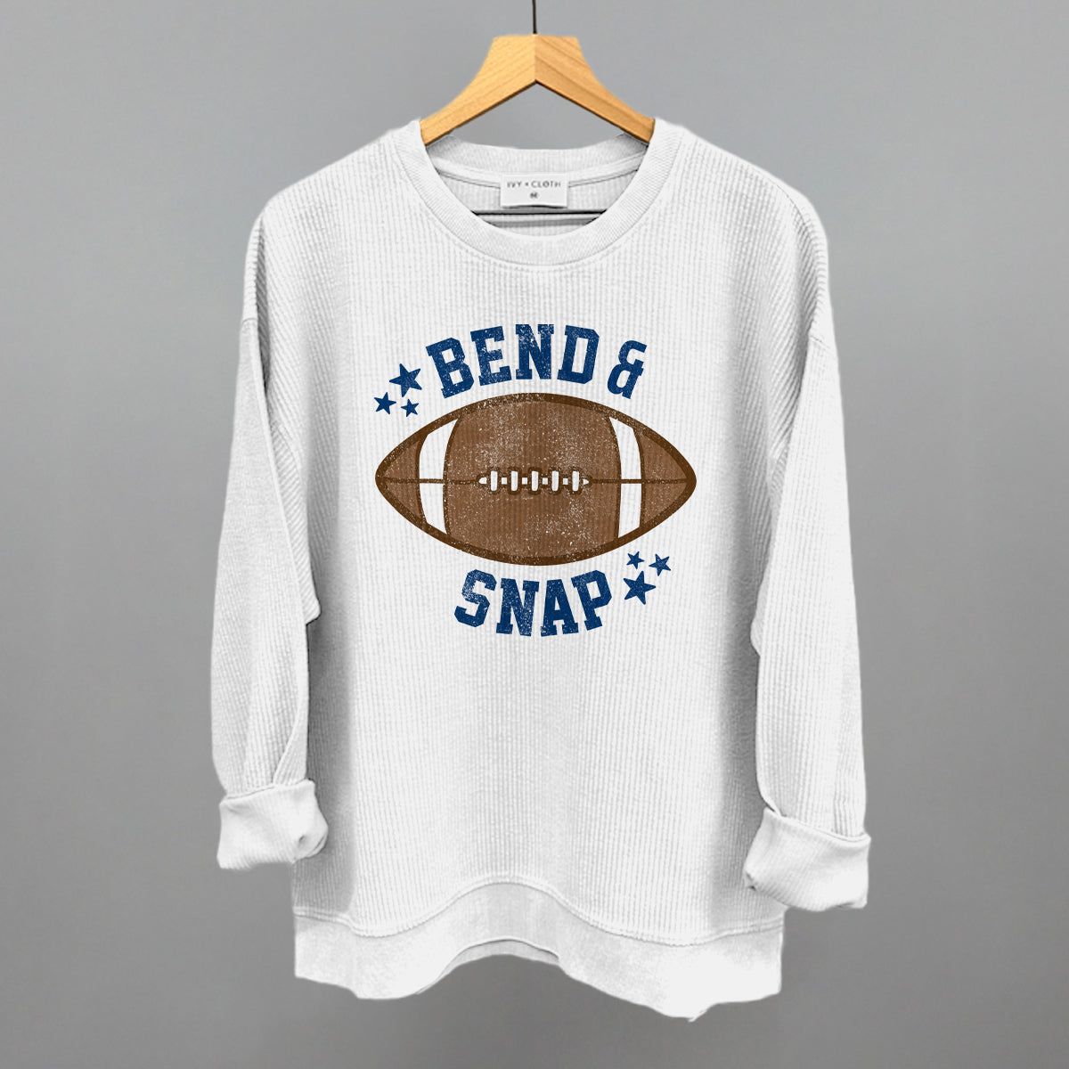 White sweatshirt with football graphic and text on a hanger against a gray background