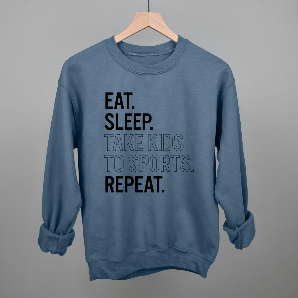 Blue comfort colors sweatshirt with text on a hanger against a gray background