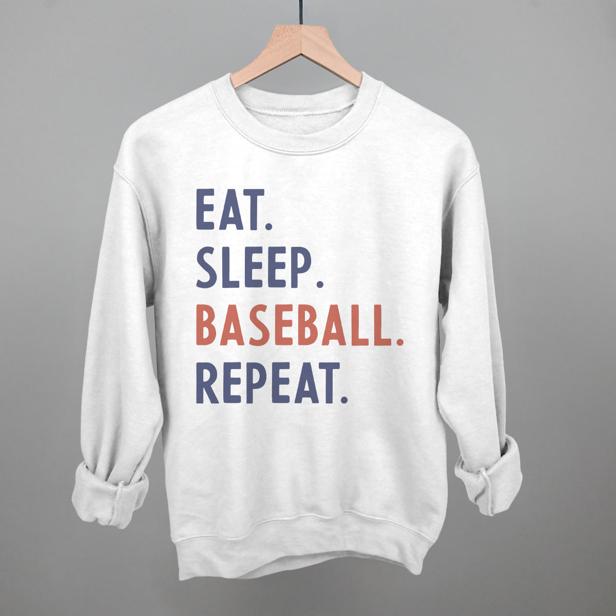 White sweatshirt with 'EAT. SLEEP. BASEBALL. REPEAT.' text on a gray background