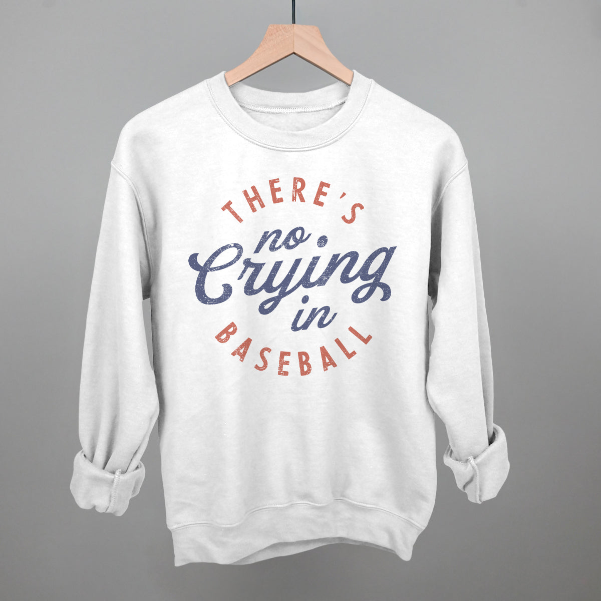 White sweatshirt with 'There's no crying in baseball' text on a gray background