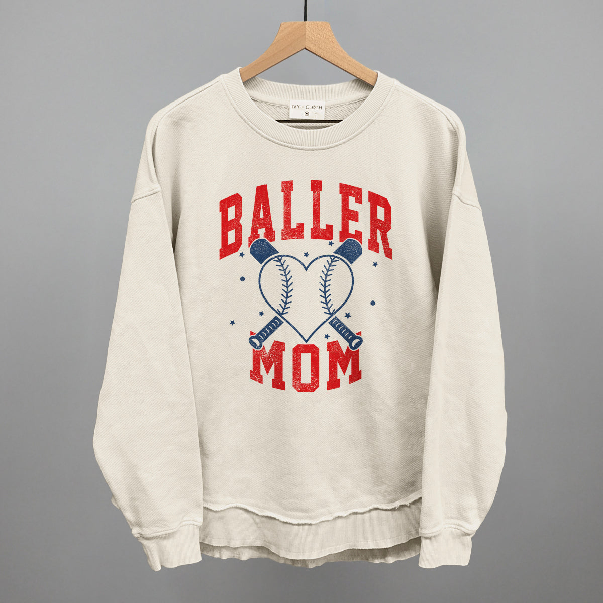Collection of Beige sweatshirt with 'Baller Mom' text and baseball graphics on a gray background in a gallery layout