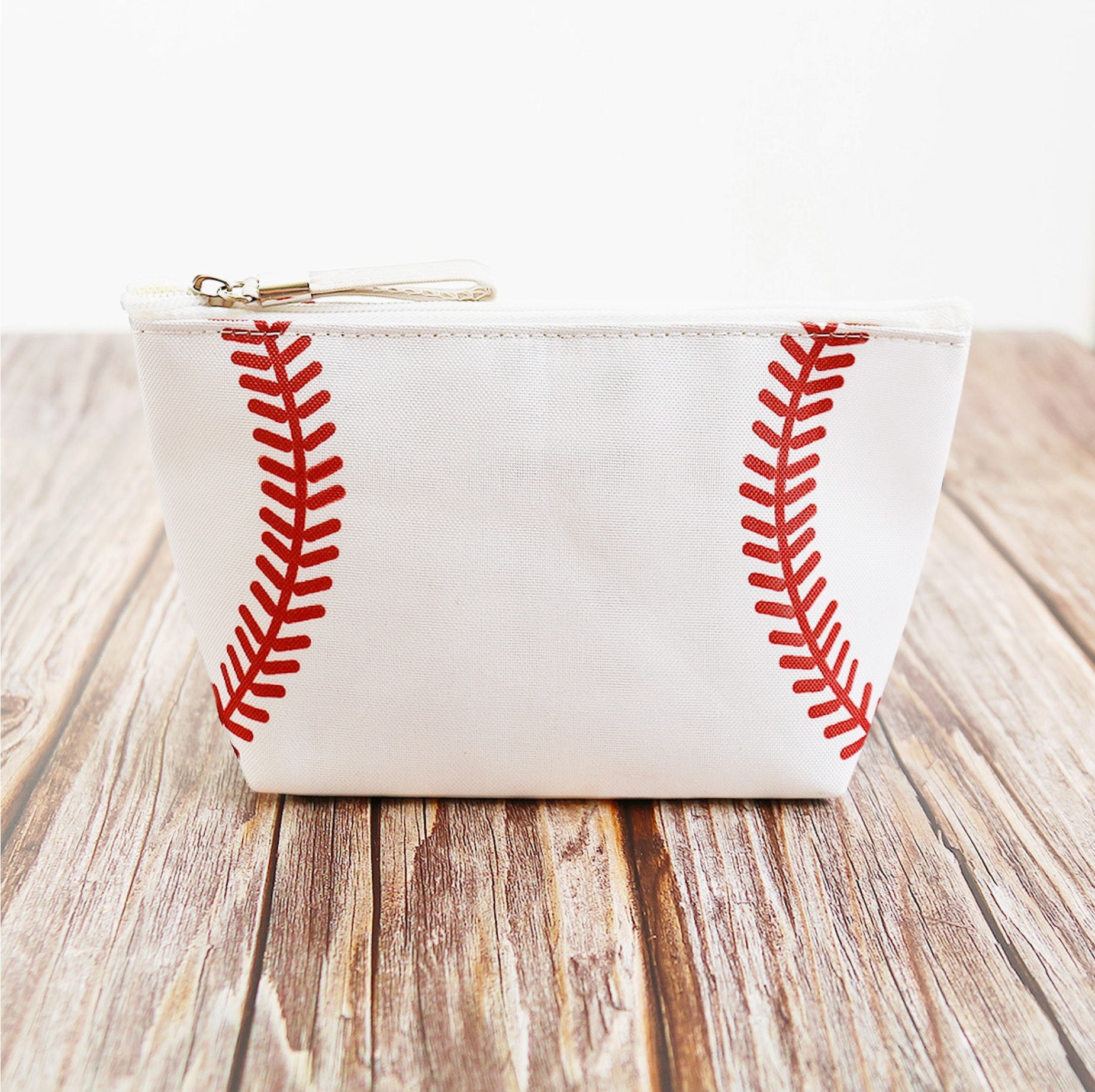 Collection of White pouch with red stitching design on a wooden surface in a gallery layout
