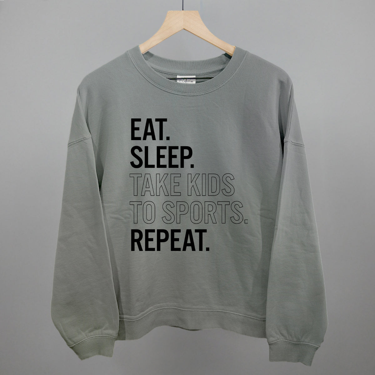 smoke sweatshirt with text 'EAT. SLEEP. TAKE KIDS TO SPORTS. REPEAT.' on a gray background