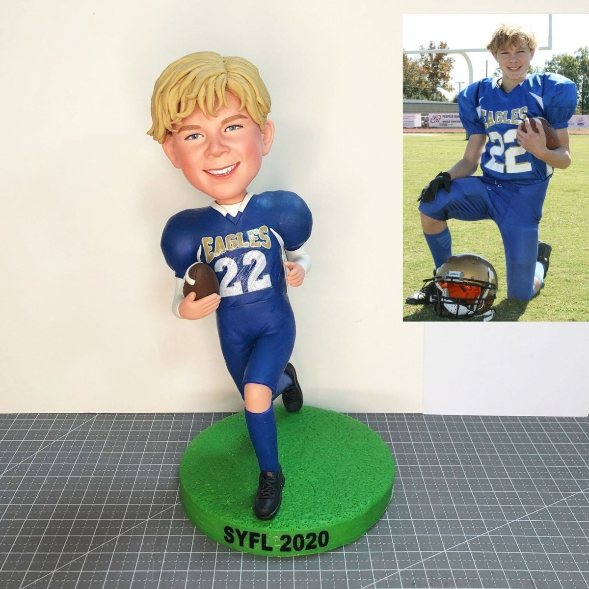 Bobblehead of a boy in a blue football uniform with a photo of the same boy on a field.