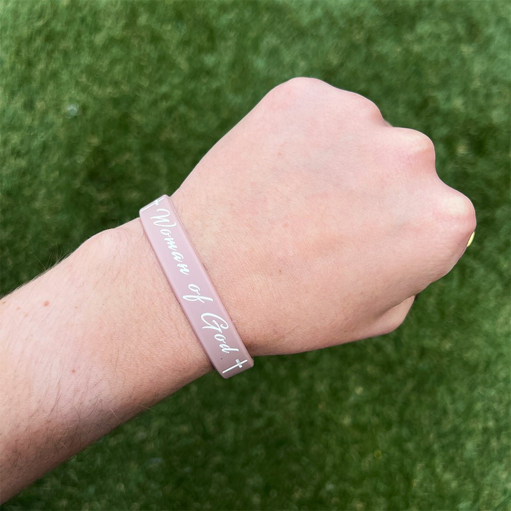 Collection of Hand wearing a pink wristband with text on a green grass background in a gallery layout