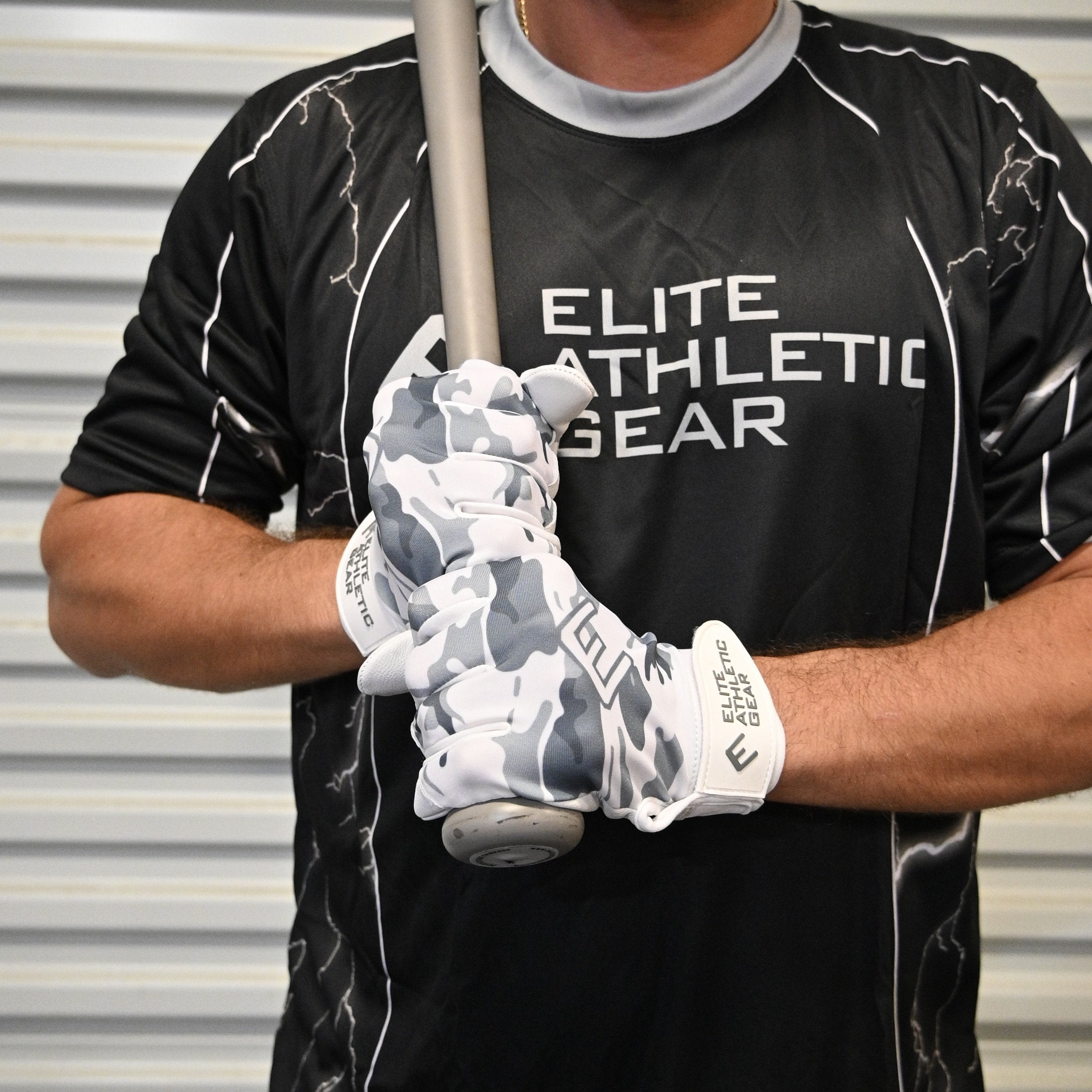Collection of Person wearing a black 'Elite Athletic Gear' shirt and holding a baseball bat with camouflage gloves. in a gallery layout