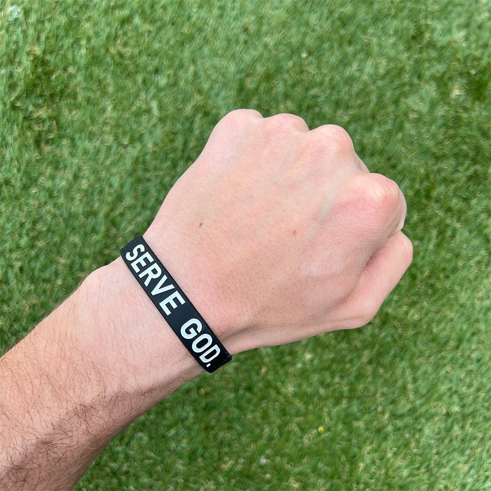 Collection of Hand wearing a black wristband with 'SERVE GOD' text against a green grass background in a gallery layout