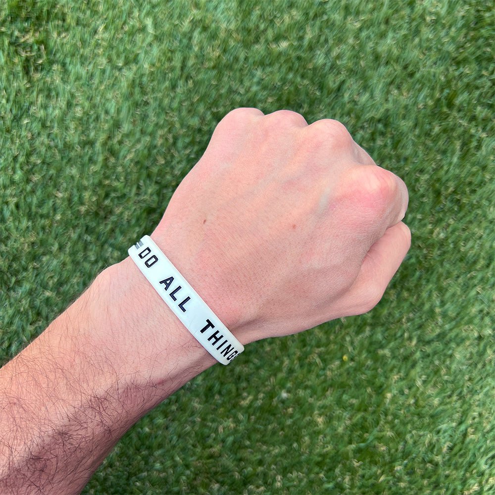 Collection of Hand wearing a wristband with text on a grass background in a gallery layout