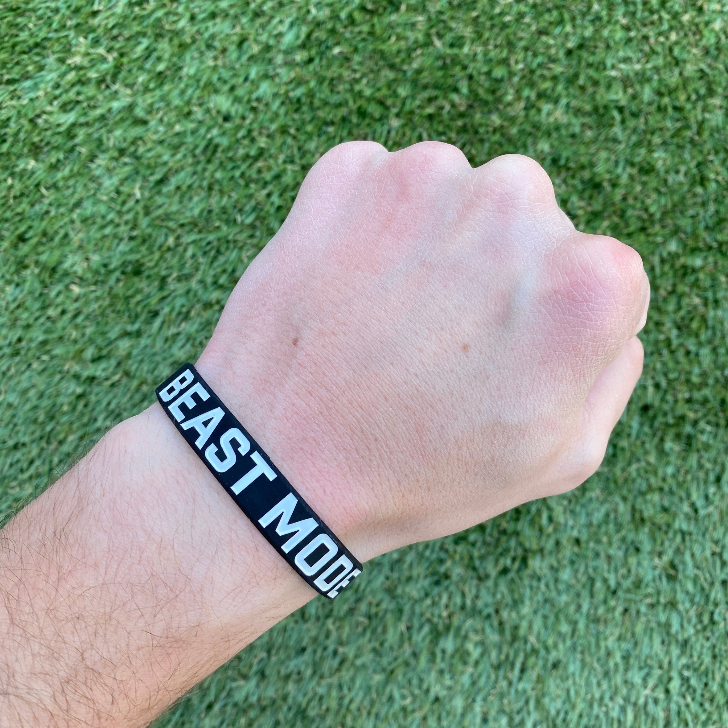 Collection of Hand wearing a 'BEAST MODE' wristband on a grass background in a gallery layout