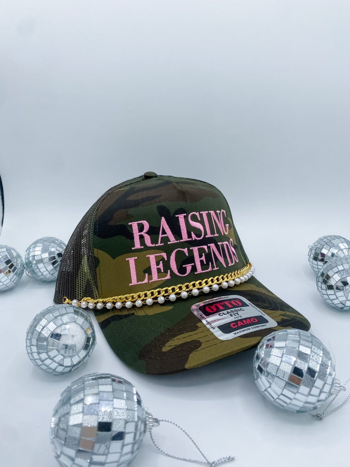Camouflage cap with 'RAISING LEGENDS' text and disco balls on a white background